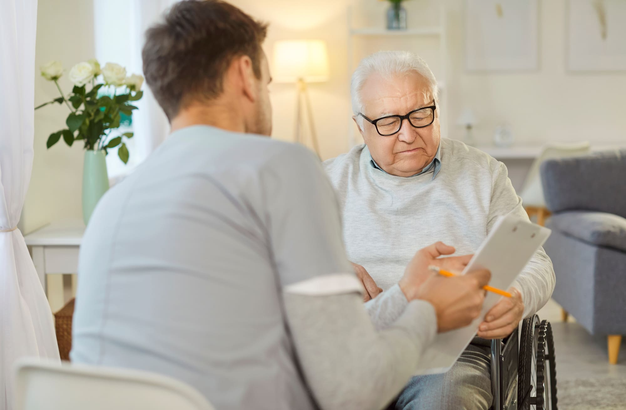 Consultation orthopédique : infirmier praticien spécialisé évaluant une douleur articulaire chez un patient âgé dans un laboratoire orthopédique