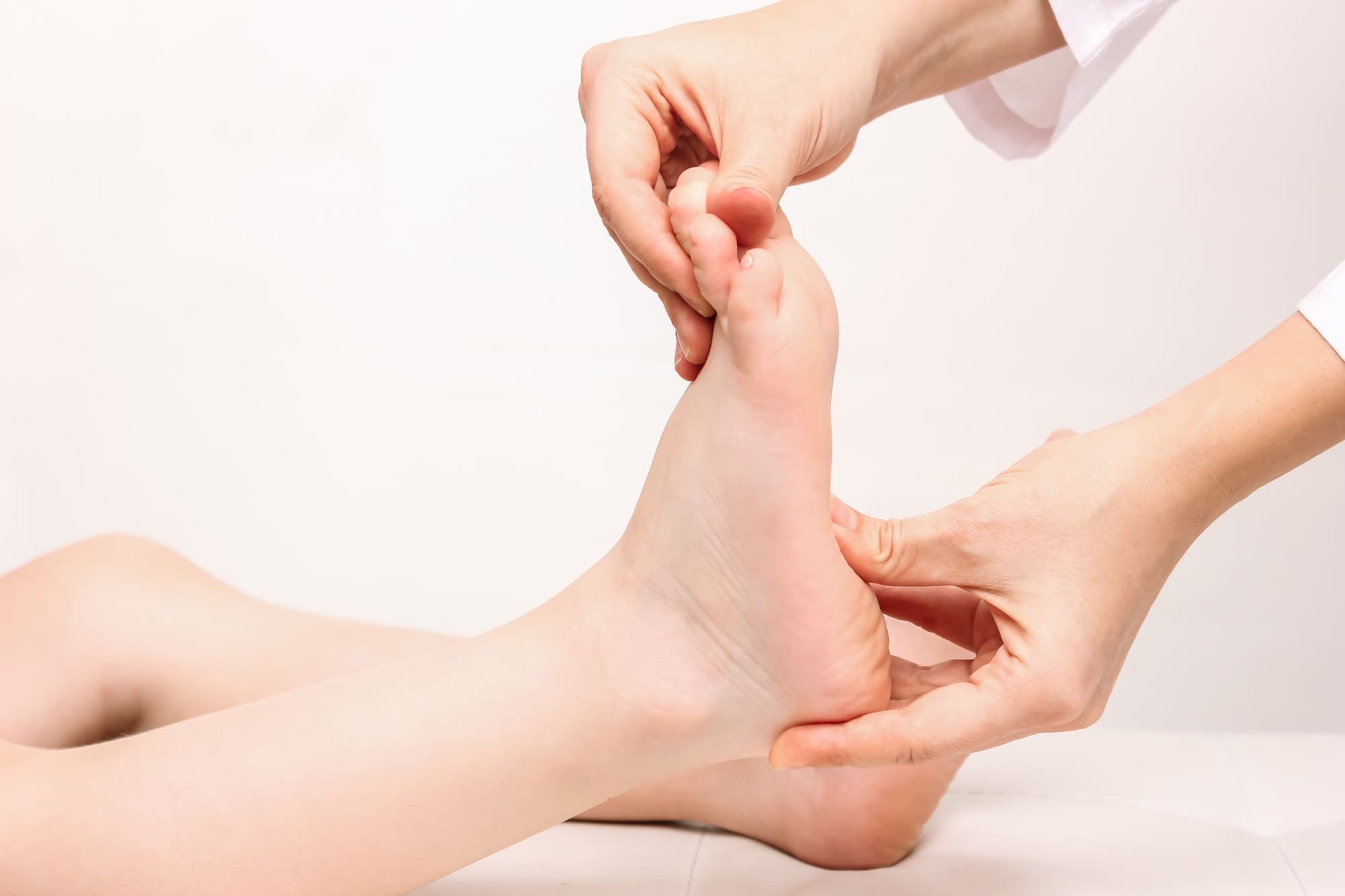 Manipulation du pied d'un enfant par un spécialiste des pieds plats.
